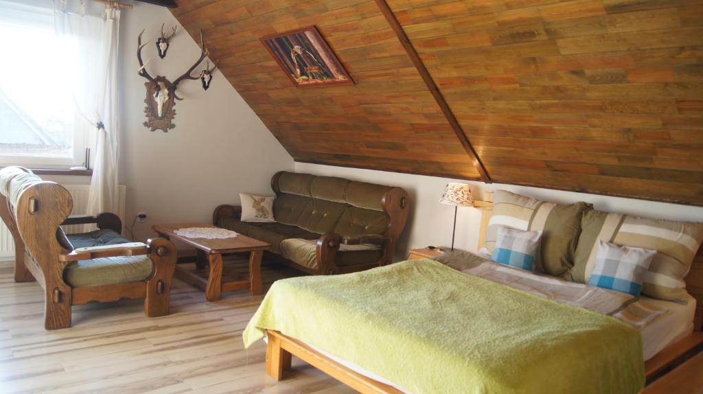 a living room with a bed and a couch at Leśny Domek in Męcikał