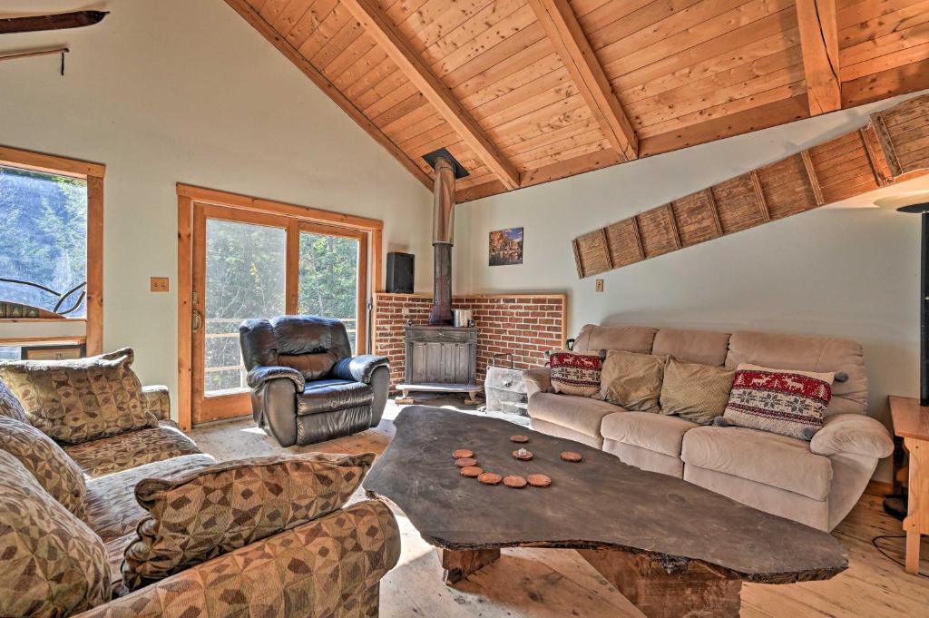 a living room with a couch and a table at Remote Cabin with Fire Pit 3 Miles to Stowe Mtn! in Stowe