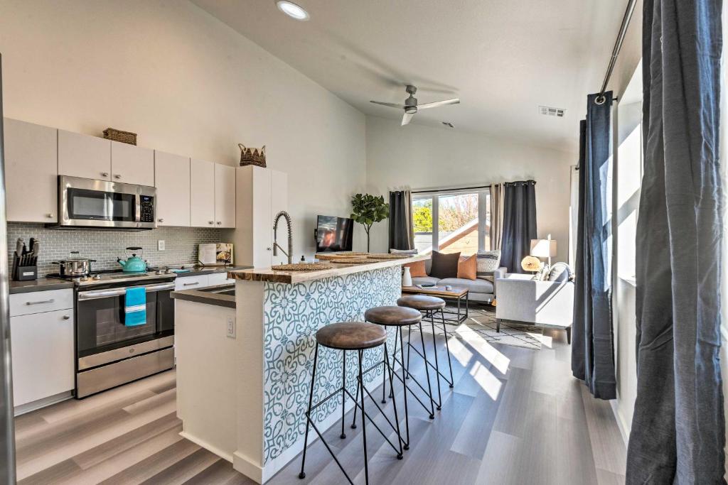 a kitchen with white cabinets and bar stools at Modern Midtown Reno Retreat Ski, Hike and Bike! in Reno