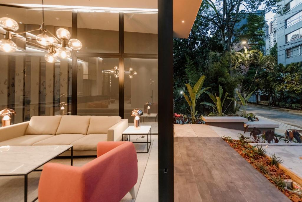 
a living room filled with furniture and a large window at Lettera Hotel in Medellín
