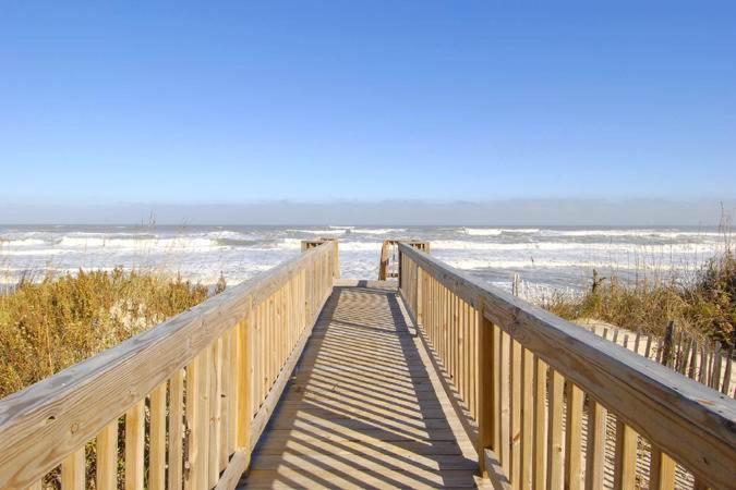 a wooden boardwalk leading to a beach with the ocean at Sea Esta 404 in Corolla