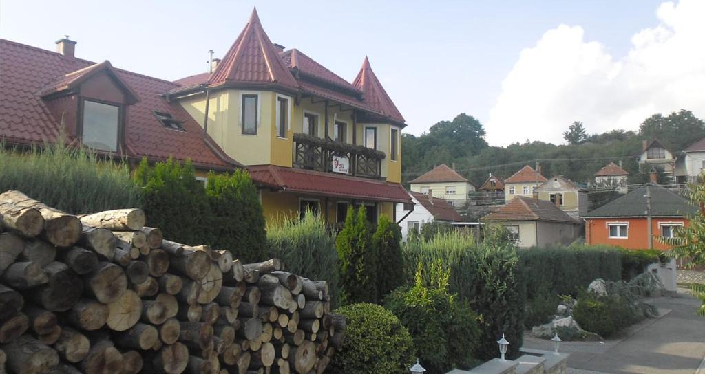 una casa amarilla con una pared de piedra delante de ella en Dudás panzió en Bükkszentkereszt