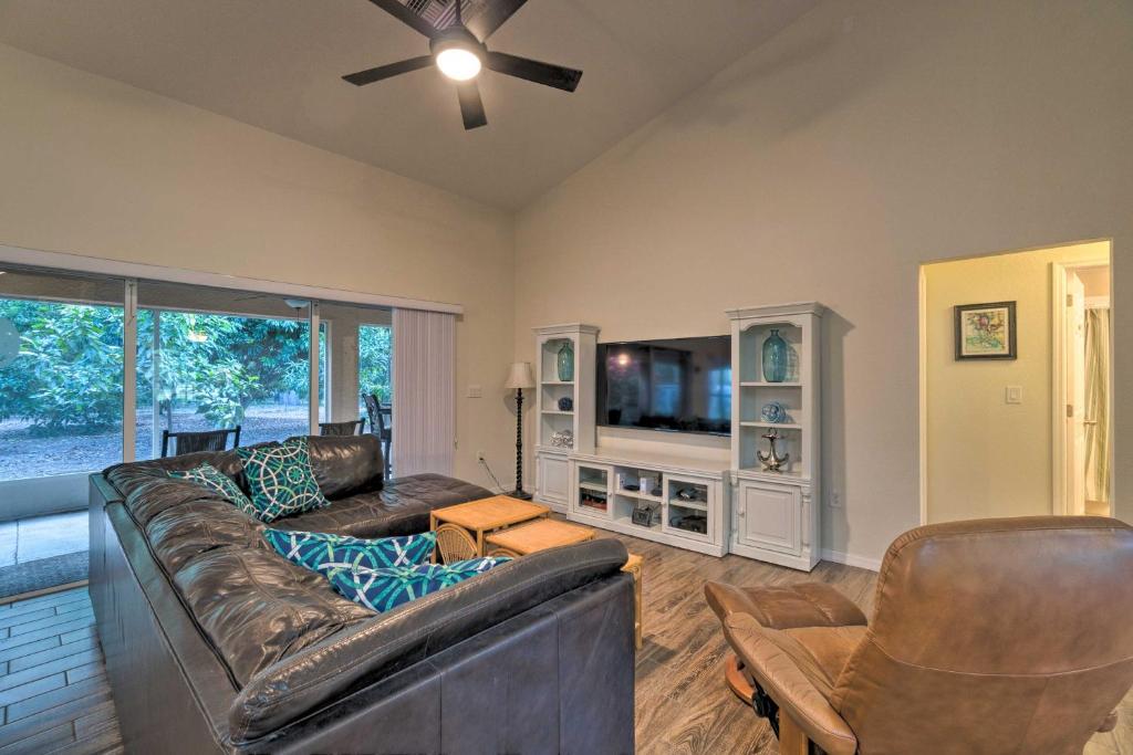 a living room with a leather couch and a tv at Breezy Gulf Coast Getaway about 4 Mi to Beach Park in Port Charlotte