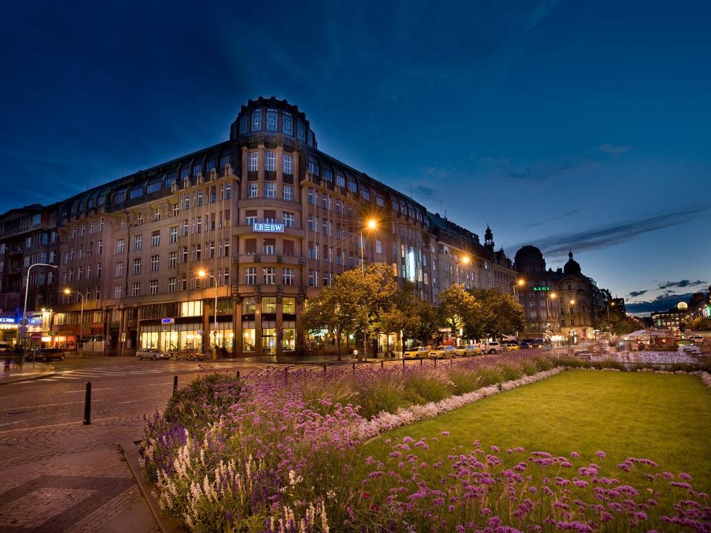 un gran edificio con un campo de flores delante de él en EA Hotel Rokoko en Praga