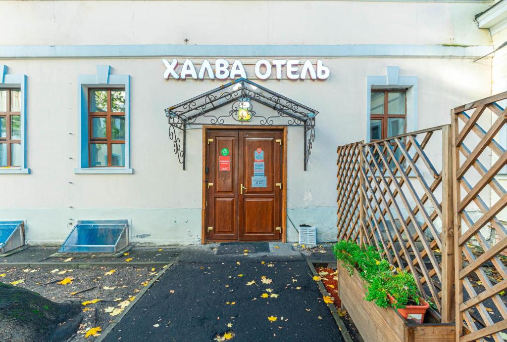 un edificio con una porta marrone e un cartello sopra di Halva Hotel Polyanka a Mosca
