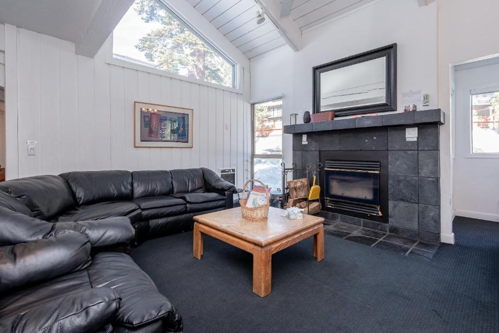 a living room with a leather couch and a fireplace at Chamonix # 62 in Mammoth Lakes
