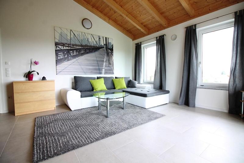 ein Wohnzimmer mit einem Sofa und einem Tisch in der Unterkunft Ferienwohnung Stocker in Seebruck