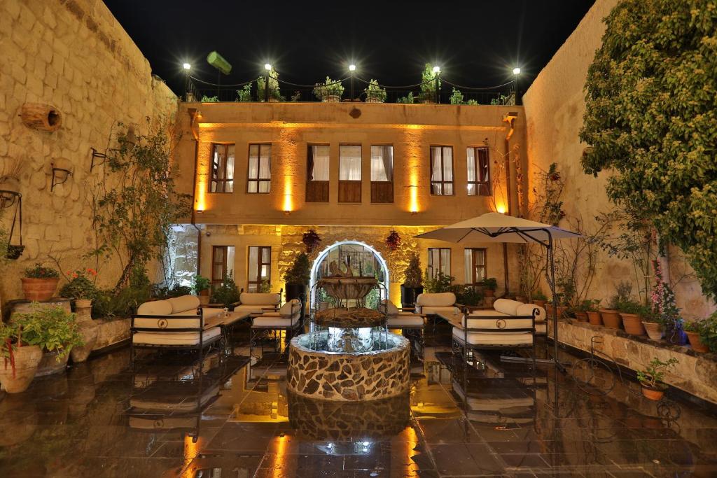 a courtyard with a fountain in front of a building at Aja Cappadocia Cave Hotel in Urgup