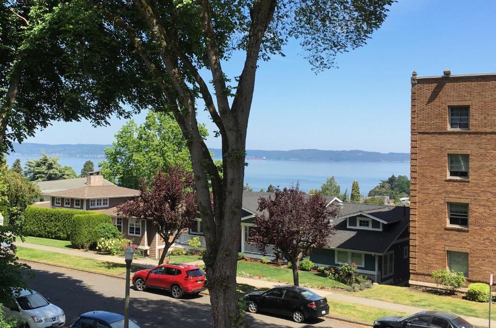 a red car parked on a street next to a building at Ocean View, 2 Baths, 2 Bedrooms, No Stairs, Best Area, WD, Jacuzzi Bath, Balcony, View, 925sf in Tacoma