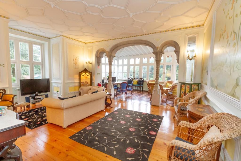 a living room with a couch and a tv at Quinta Das Murtas in Sintra