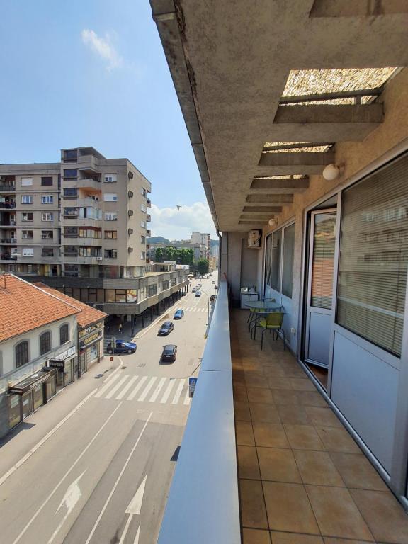 Elle comprend un balcon offrant une vue sur une rue de la ville. dans l'établissement Apartman Panorama 3 Glavna ulica, à Užice