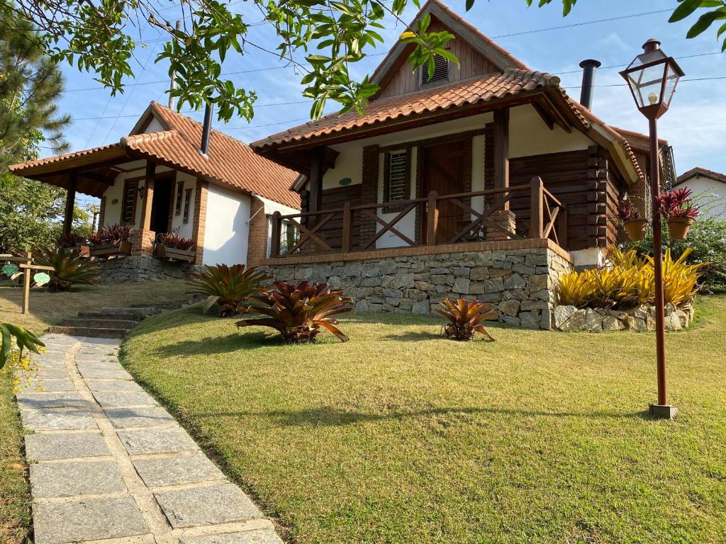 a house with a pathway in front of it at Pousada das Bromélias in Ipiabas