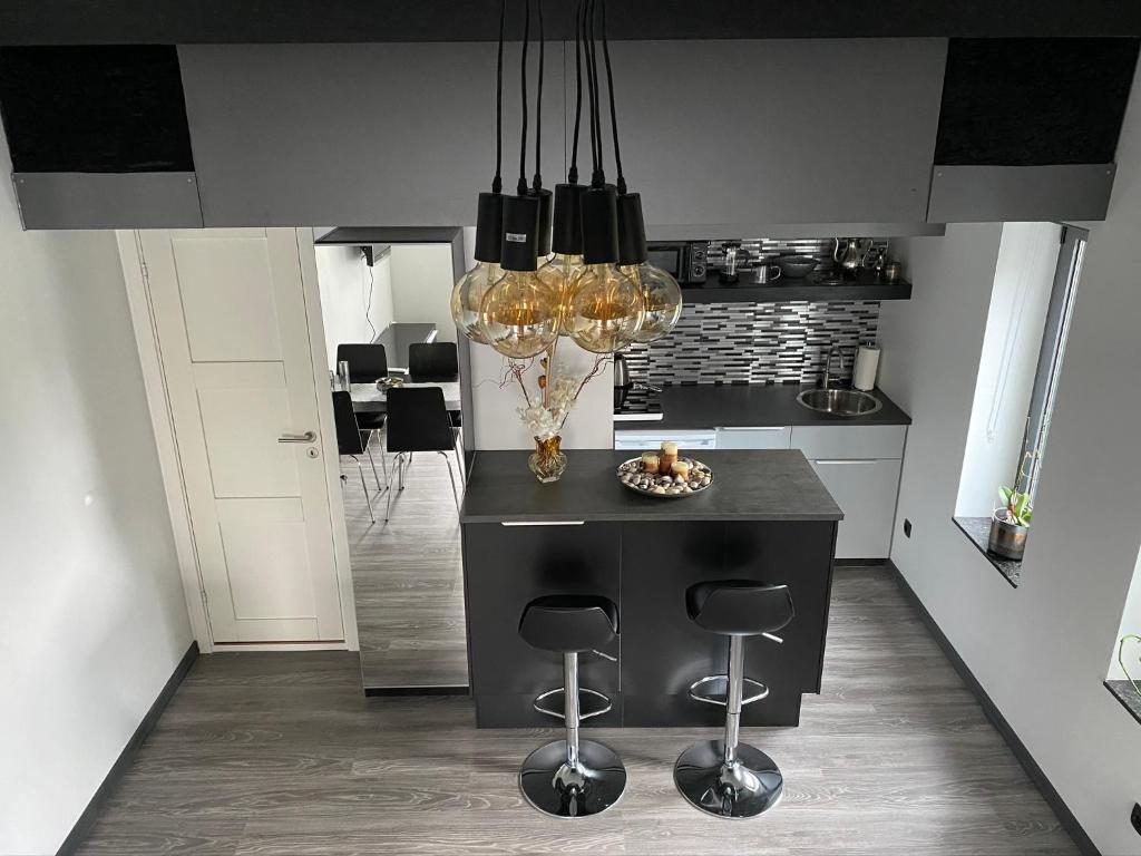 a kitchen with a black island with stools at Studio Apartment 7Heaven in Malmö