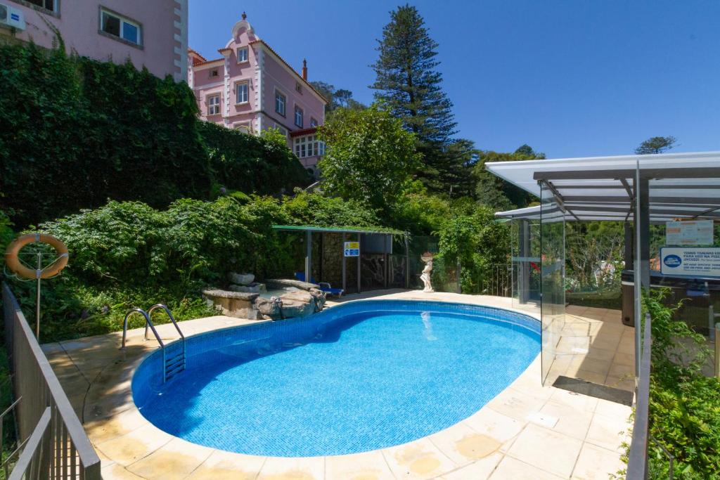a swimming pool in a yard with a house at Quinta Das Murtas B&B in Sintra