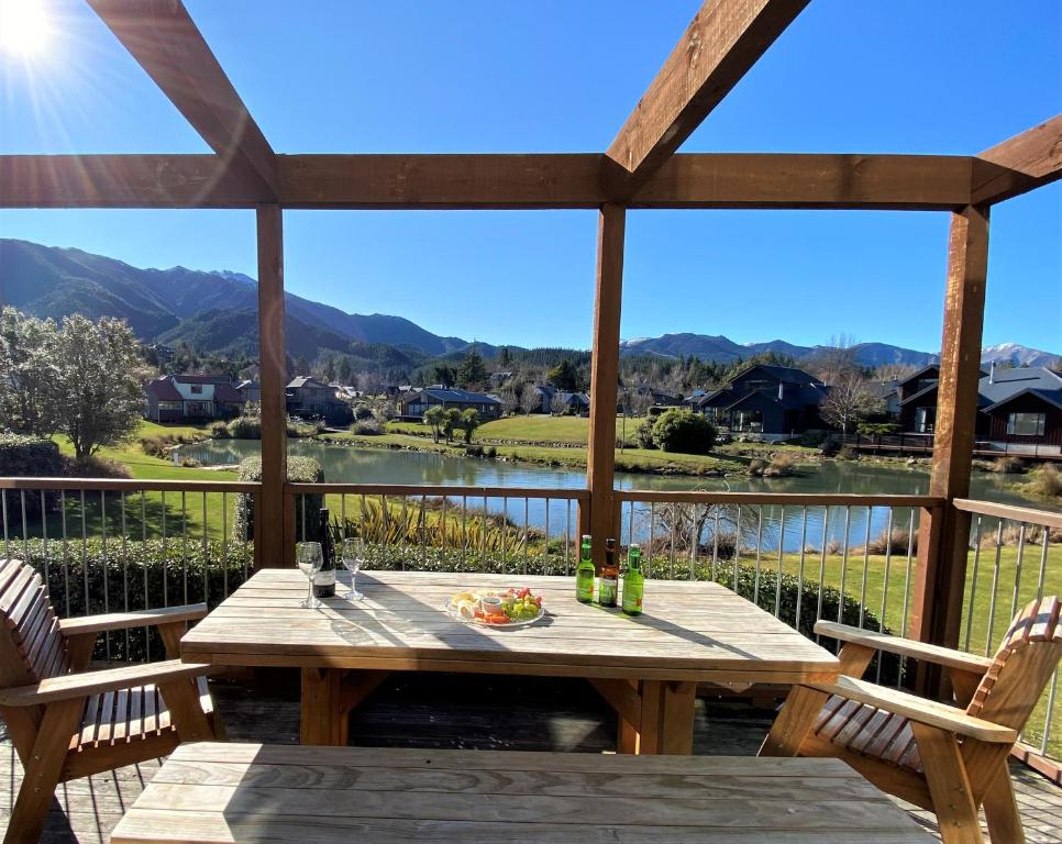a table on a deck with a view of the mountains at *** LAKE VILLA 459 *** in Hanmer Springs