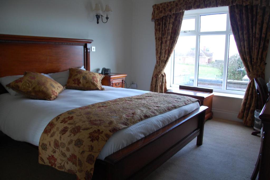 a bedroom with a large bed and a window at The Down Inn in Bridgnorth