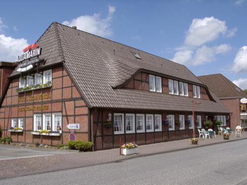 ein braunes Gebäude mit schwarzem Dach auf einer Straße in der Unterkunft Hotel Krohwinkel in Hittfeld