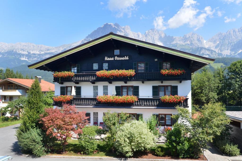 a black and white building with flowers in front of it at Appartements Oswald in Ellmau