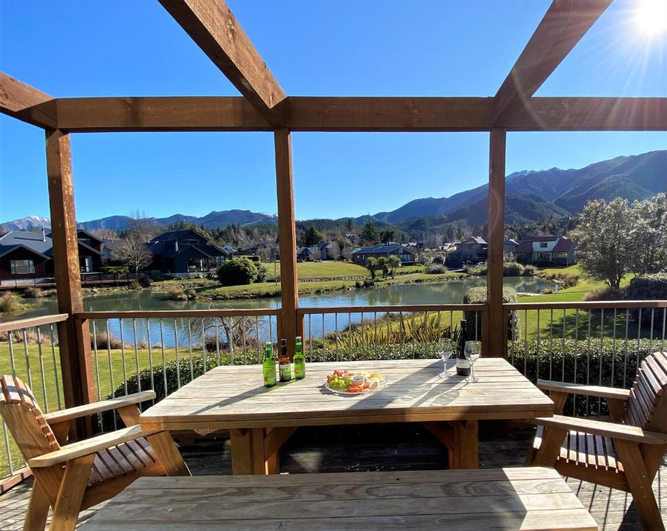 una mesa en una terraza con vistas a las montañas en *** LAKE VILLA 461 ***, en Hanmer Springs