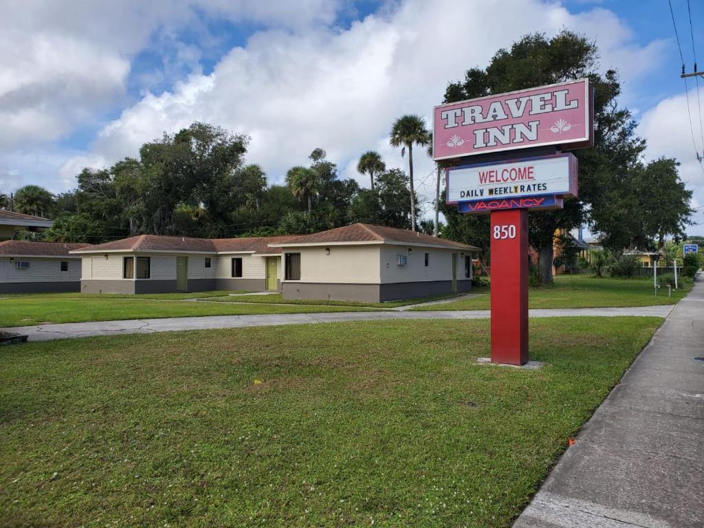 ein Schild für ein Reisegasthaus vor einem Haus in der Unterkunft Travel Inn Daytona in Daytona Beach