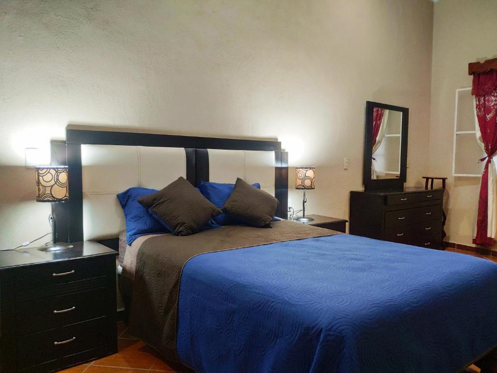 - une chambre dotée d'un lit avec des draps bleus et un miroir dans l'établissement Habitación Hansa, à Puerto Vallarta