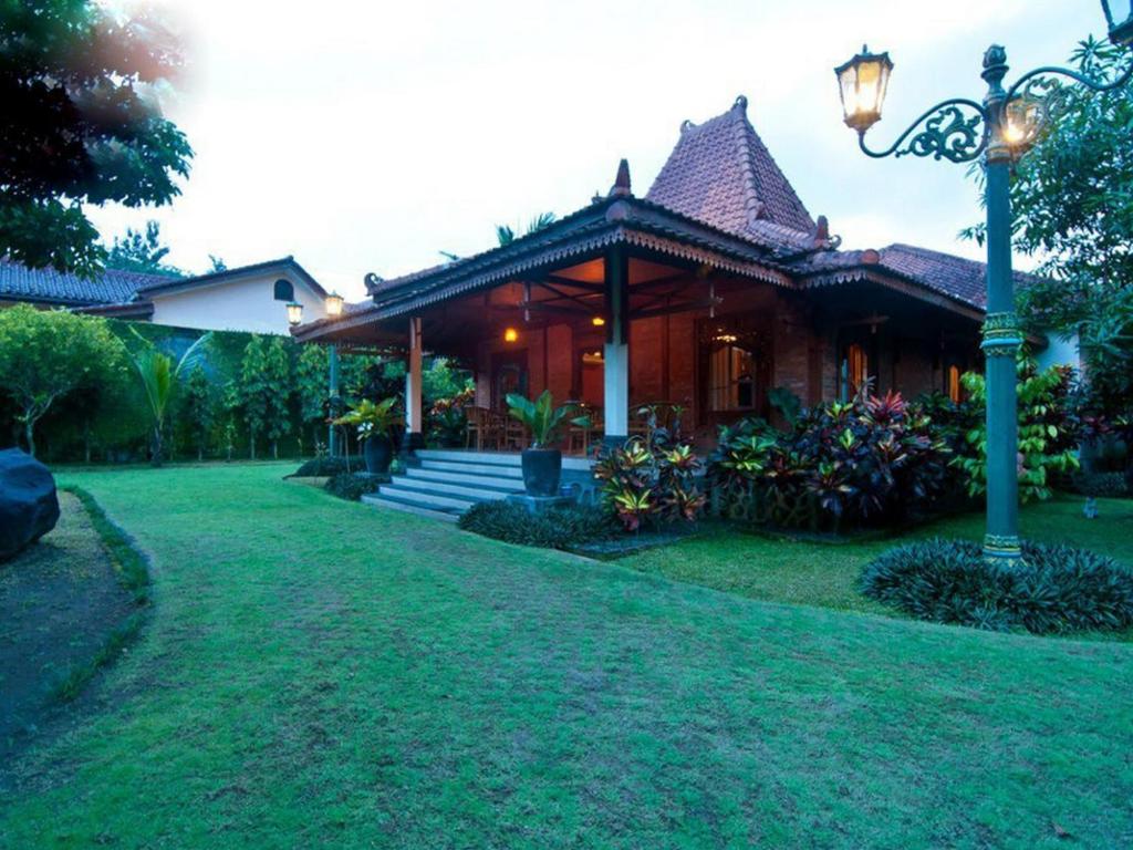 une maison avec un pôle lumineux devant elle dans l'établissement Alam Jogja Resort Mitra RedDoorz, à Yogyakarta