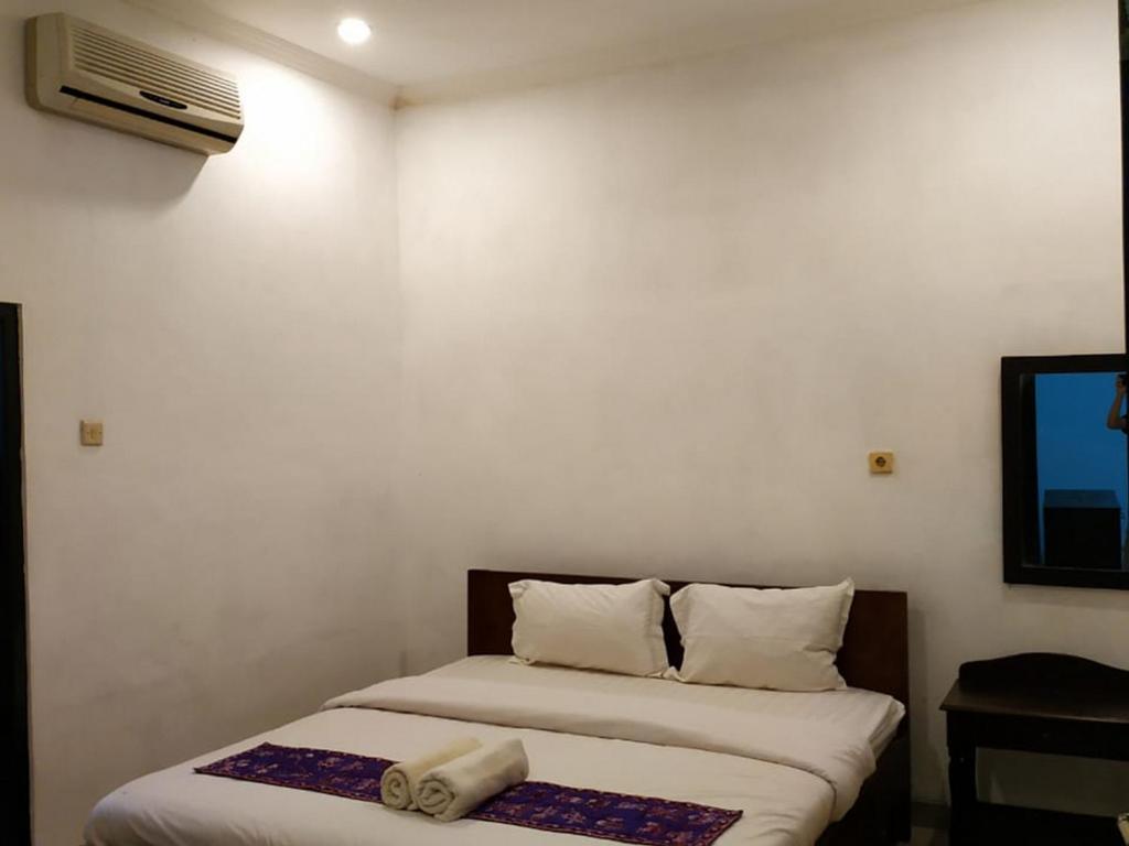 Postel nebo postele na pokoji v ubytování Alam Jogja Resort Mitra RedDoorz