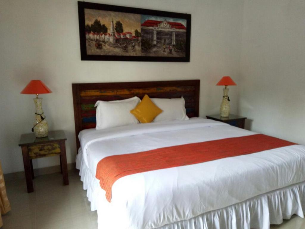 Postel nebo postele na pokoji v ubytování Alam Jogja Resort Mitra RedDoorz