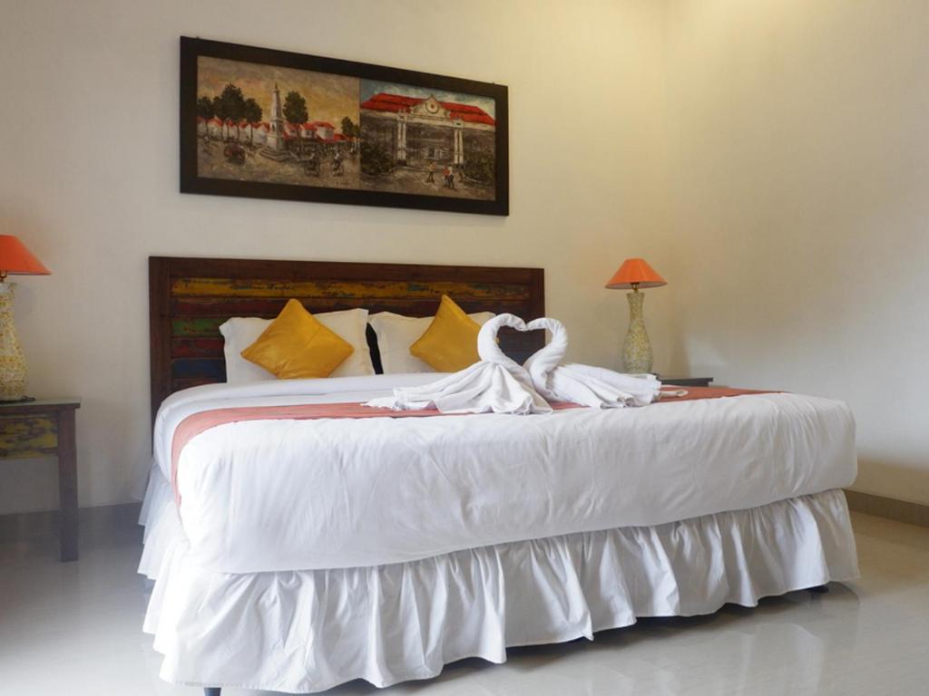 Postel nebo postele na pokoji v ubytování Alam Jogja Resort Mitra RedDoorz
