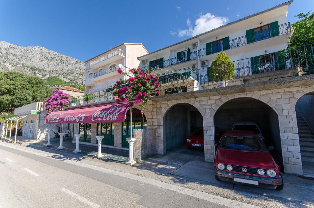 a red car parked in front of a building at Apartments Moloco in Drvenik