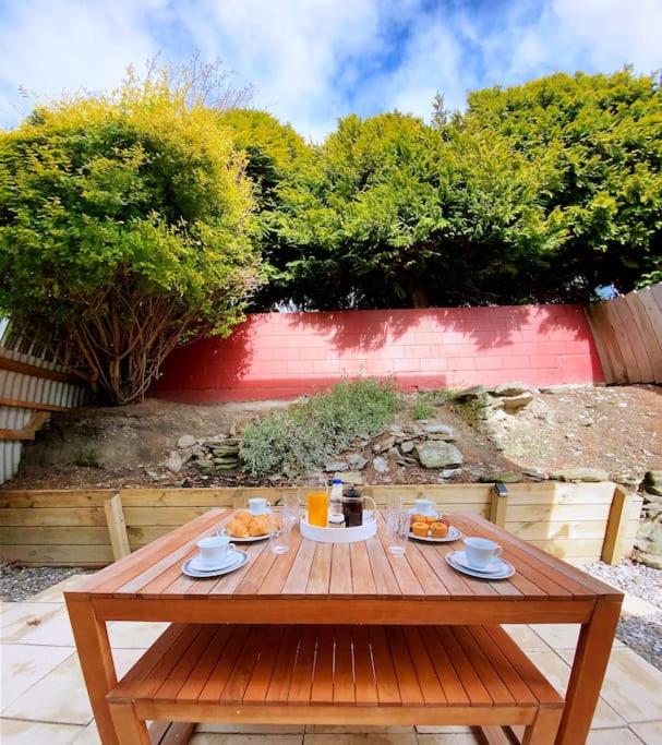 a wooden table with food and drinks on it at Hideaway Rima - in the CBD in Queenstown