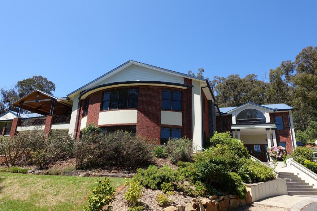 a large brick house with a staircase in front of it at Elkanah Lodge and Conference Centre in Marysville