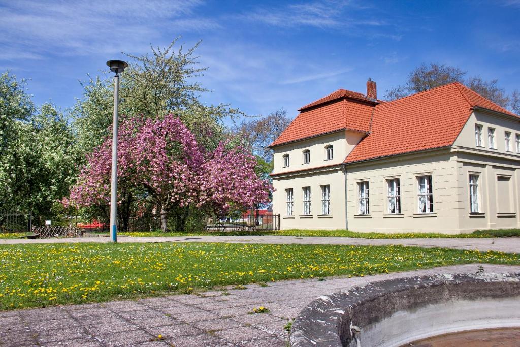 ein großes weißes Haus mit rotem Dach in der Unterkunft Gästehaus Schloss Plaue in Brandenburg an der Havel