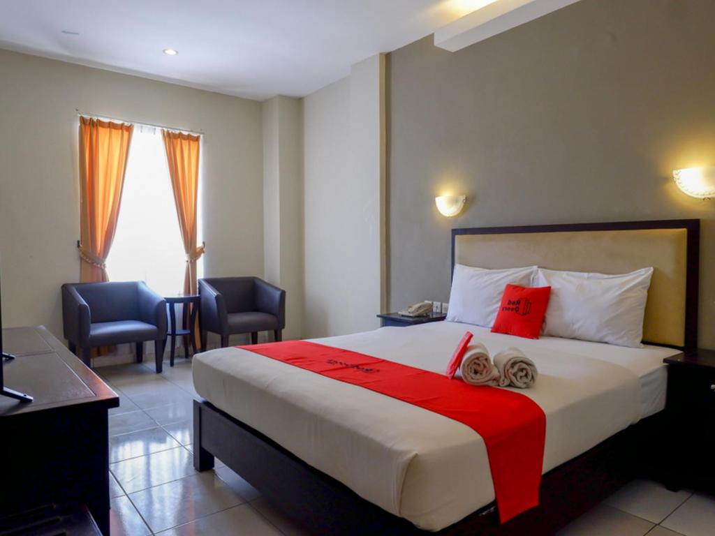 een hotelkamer met een groot bed met rode kussens bij RedDoorz At Jalan Sriwijaya Semarang in Semarang