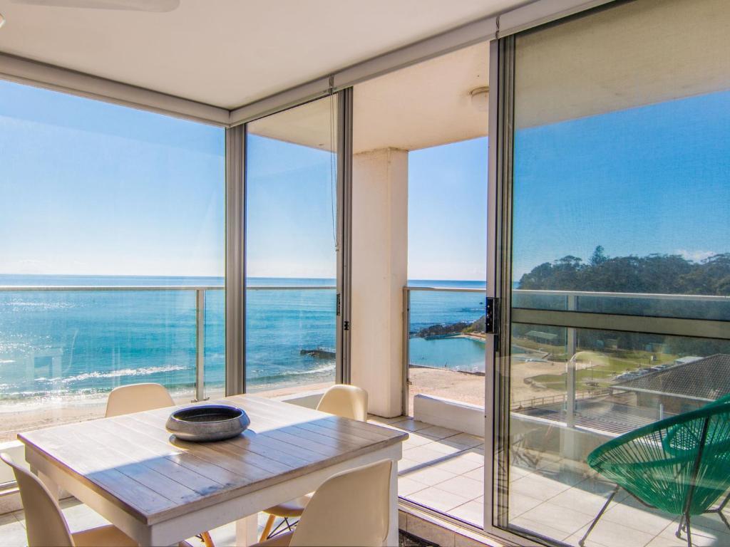 a dining room with a table and views of the ocean at Oceanic 26 in Forster