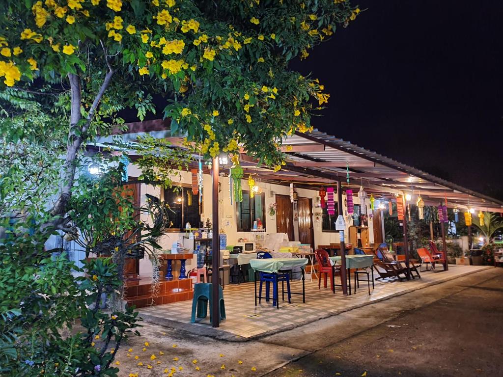 un restaurante con mesas y sillas al aire libre por la noche en Bunrapee House en Nan