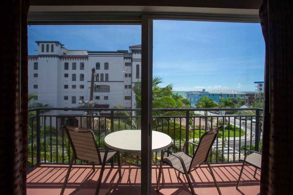 einen Balkon mit einem Tisch und Stühlen sowie Blick auf ein Gebäude in der Unterkunft 409 - Madeira Bay Resort in St Pete Beach