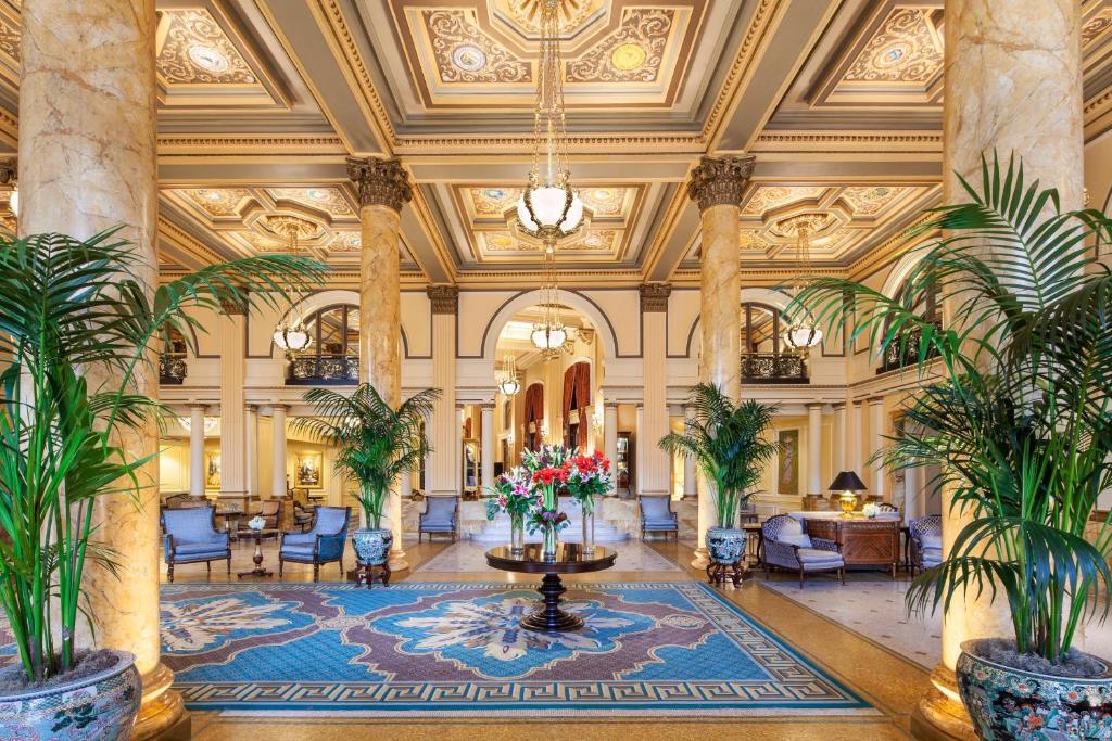 a lobby with palm trees and a chandelier at Willard InterContinental Washington, an IHG Hotel in Washington
