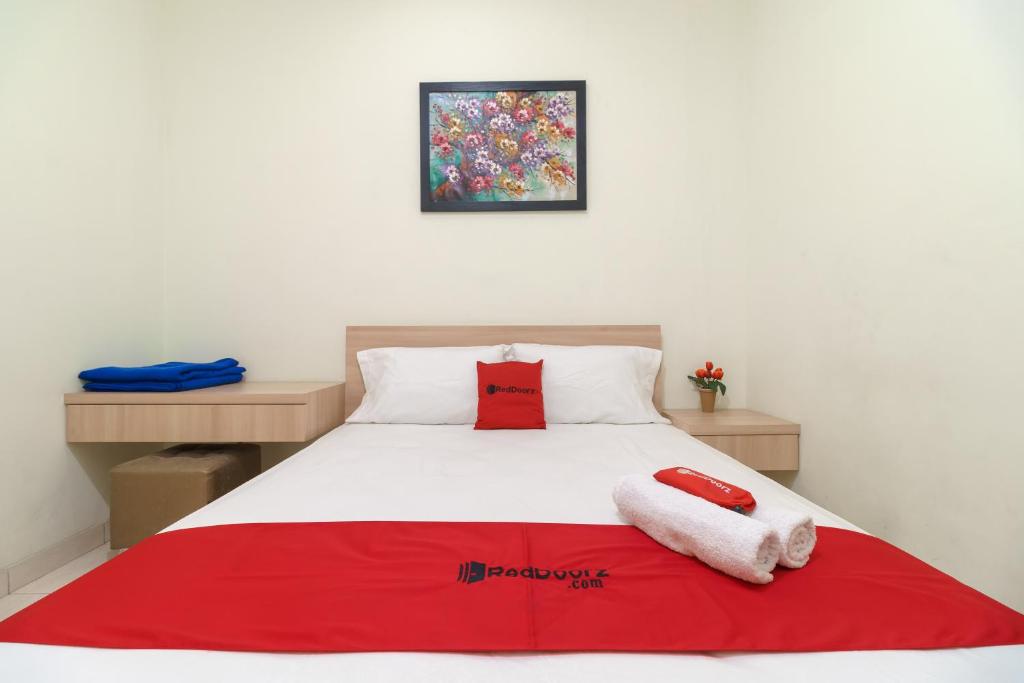 1 dormitorio con 1 cama con 2 toallas en RedDoorz Syariah @ Cinere Depok en Depok
