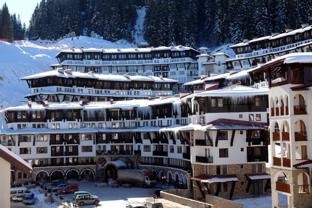 a group of buildings with snow on their roofs at GRAND MONASTERY Apartments in Pamporovo