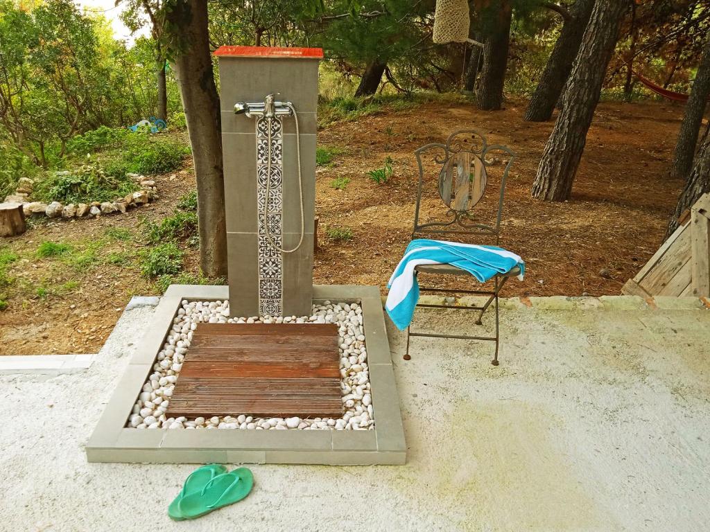 a outdoor grill with a shower and a chair at Quercus Apartment in Stara Baška