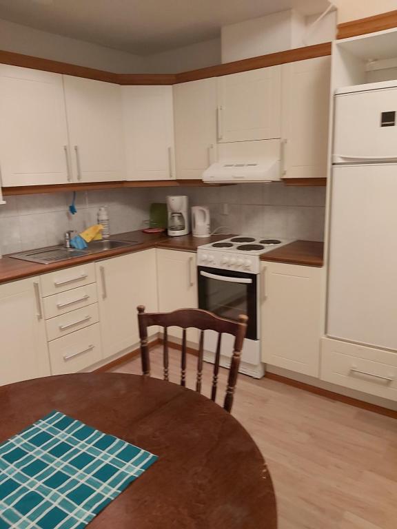a kitchen with a table and a white refrigerator at Ruskalinna Apartments in Pello
