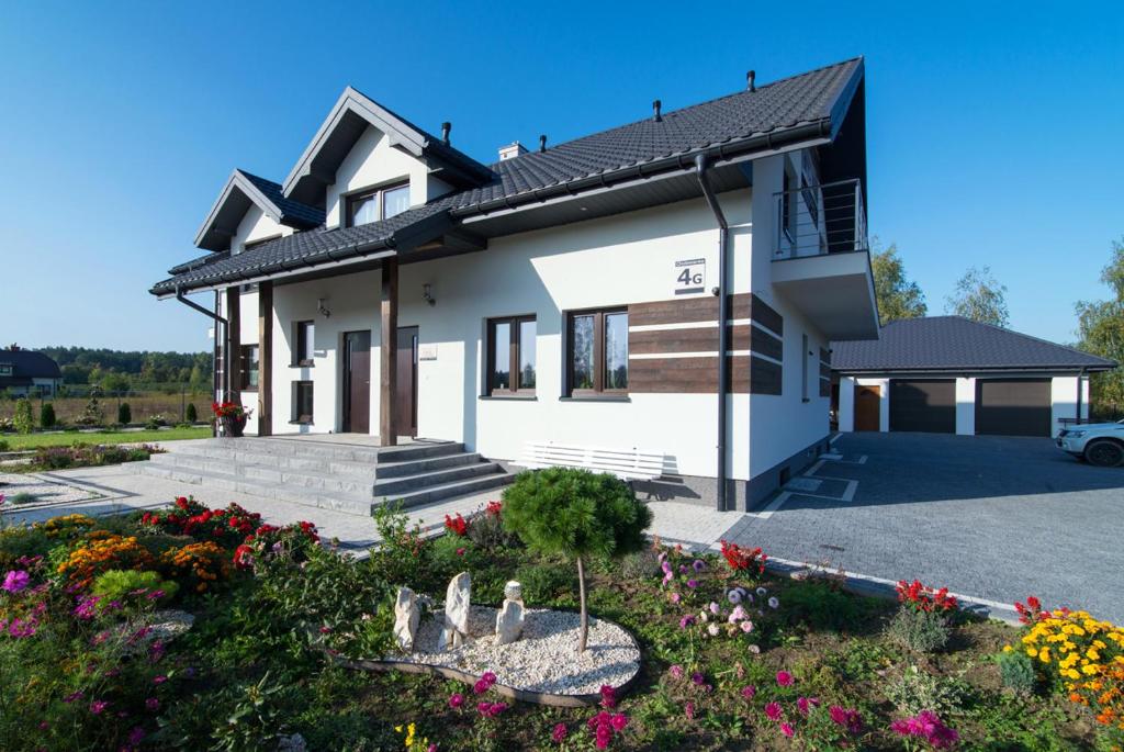 una casa con muchas flores delante de ella en Za Gościńcem, en Kazimierz Dolny