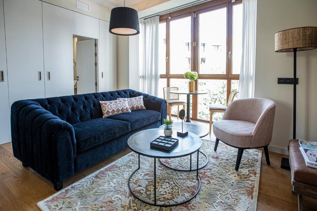 ein Wohnzimmer mit einem blauen Sofa und einem Tisch in der Unterkunft Palma Suites in Palma de Mallorca
