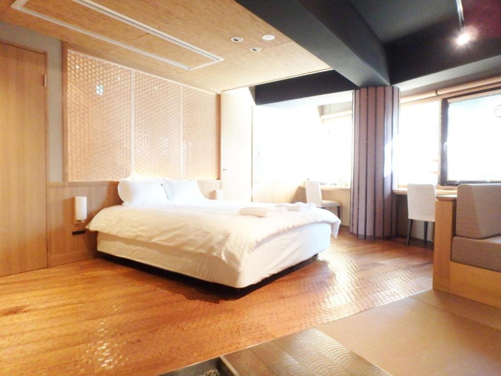 a bedroom with a large white bed and a window at Gion Suite in Kyoto