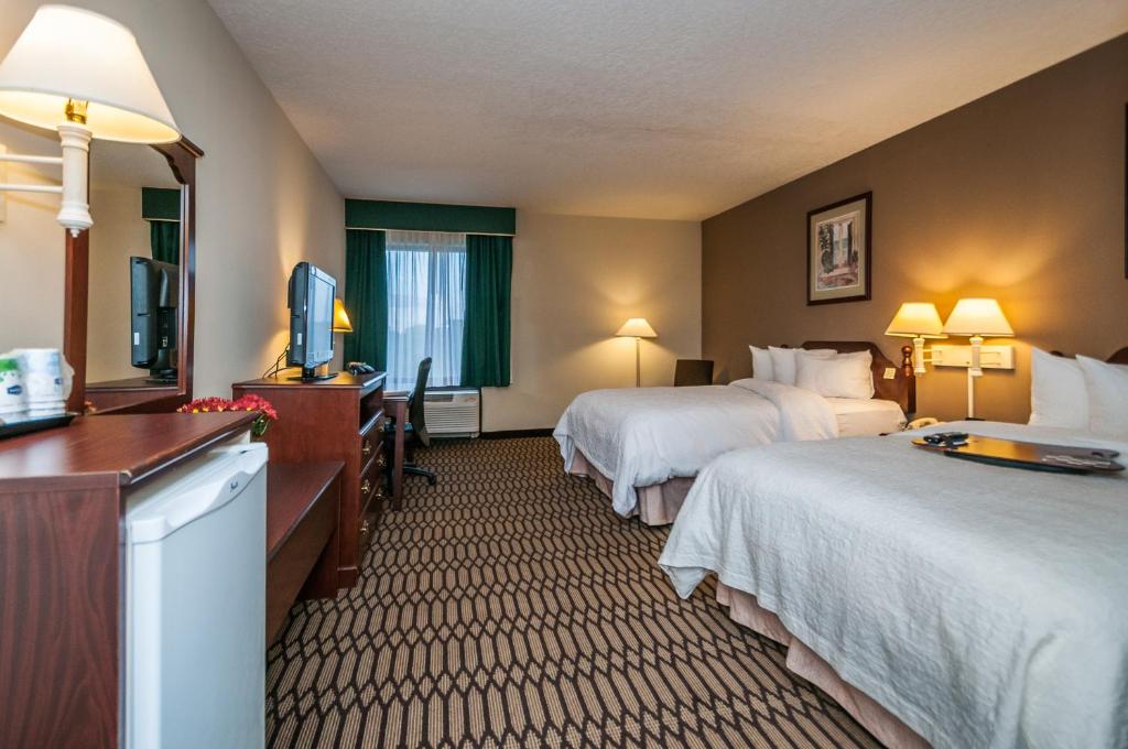 a hotel room with two beds and a flat screen tv at Holiday Inn - St. Petersburg West by IHG in St Petersburg