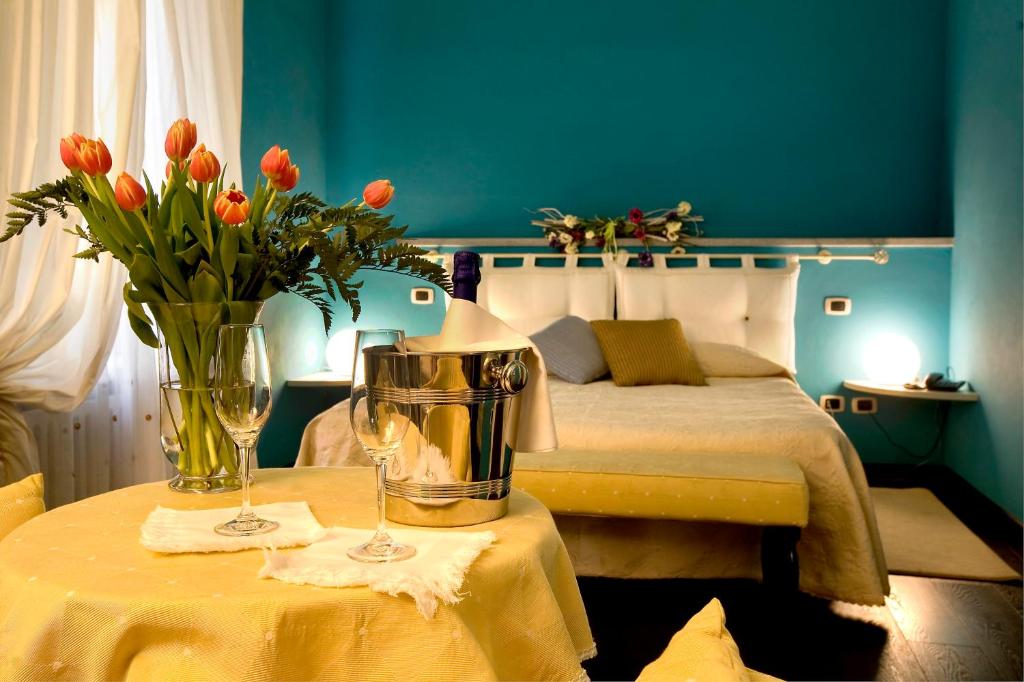 Hotel Cascina Di Corte في فيناريا ريالي: غرفة نوم بسرير وطاولة عليها ورد
