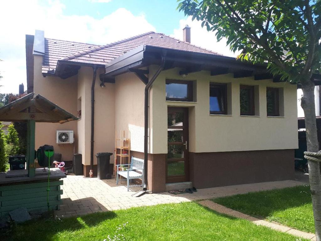 a small house with its door open in a yard at Aranypatak apartmanház in Szombathely