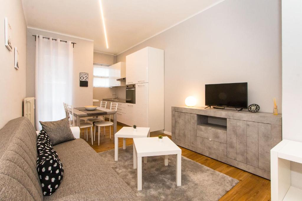 uma sala de estar com um sofá e uma televisão em MM Pozzo Strada Terrace Apartment em Turim