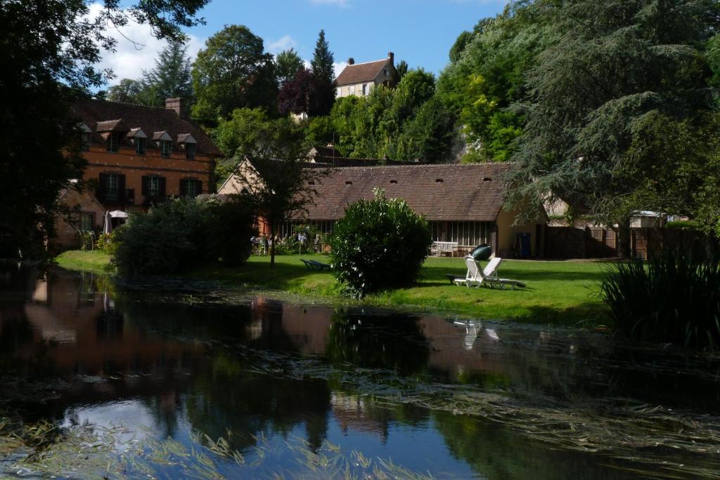 a house next to a river with a building at Domaine De Villeray in Condeau